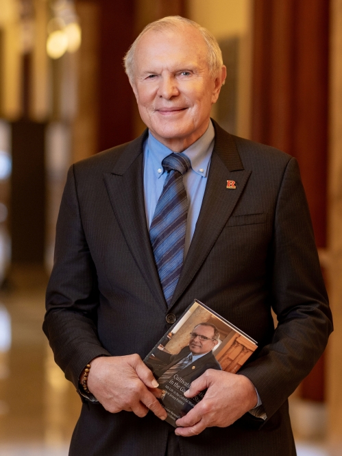 Senator Raymond Lesniak holding memoir in New Jersey statehouse. Photo by John O’Boyle.